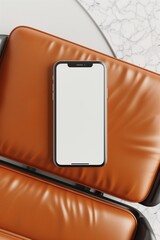 Poster - Smartphone with a blank screen displayed on an orange leather chair with a marble table nearby.
