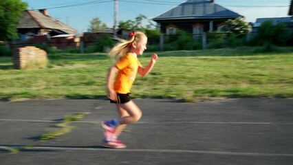 Wall Mural - girl in an orange sweater runs, children's sports, child plays sports, jogging, run