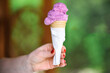 Woman's hand holding a ice cream cone with berry