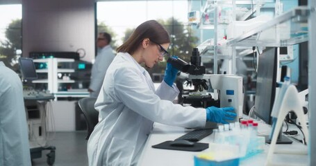 Leinwandbilder - Portrait of a Beautiful Caucasian Student Working on a Research Project in University. Medical Research Scientist Looking at Biological Samples Under a Microscope in an Applied Science Laboratory