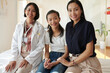 © DragonImages - Portrait of smiling mother daughter and pediatrician sitting on bed in hospital ward
