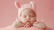 Cute studio photography of a newborn baby girl sleeping with cute props on soft pink background