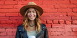 Smiling Young Woman in Hat Against Red Brick Wall with Coffee