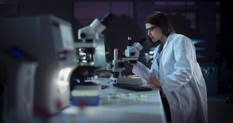 Aufkleber - Cinematic Footage with a Beautiful Young Scientist Making an Important Innovative High Tech Discovery while Sitting in a Laboratory and Working with Microscope. Evening in Medical Research Center