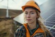 Female engineer with helmet near solar panels