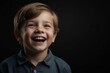 young british child boy on plain bright black background laughing hysterically looking at camera background banner template ad marketing concept from Generative AI