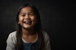 young filipino child girl on plain bright black background laughing hysterically looking at camera background banner template ad marketing concept from Generative AI