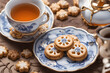Everything for wonderful tea party. White porcelain cup with blue pattern. And saucer of beautiful glazed shortbread cookies.