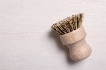 Canvas Print - Cleaning brush on light wooden table, top view. Space for text