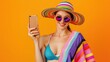 Photo of funny lady summer time holding telephone sending best friend photos from tropical ocean resort wear sun hat specs stylish beach cape isolated orange background.