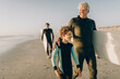 © Marko Geber - Three generations of men in wetsuits on the beach