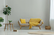 Sofa with a yellow blanket and a wooden coffee table in a grey living room interior with a dining area