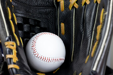 Wall Mural - white baseball with red stitching resting in black/brown glove