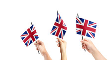 A Group Of People Are Holding Small Flags Of United Kingdom In Their Hands.