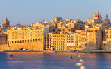 Fototapeta Boho - Old stone traditional multi-storey buildings over Valletta Bay on a sunny morning.