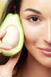 Half an avocado and half woman's face close-up