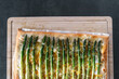 Spargelpizza zu Hause selber machen mit grünem Spargel auf Holzbrett