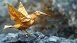A golden origami bird stands on a rock