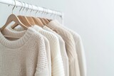 Fototapeta  - A rack of white clothing hangs on a white wall. The clothes are all white and are neatly hung on the rack. Scene is calm and organized