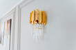 Fashion accessory A gold wall light with clear crystals on white wall