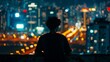 A man is standing on a ledge looking out over a city at night
