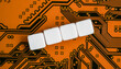 Electronic orange printed circuit board, with four empty white beads small cubes, detail view from above