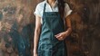 Closeup of a woman pointing at a kitchen apron against a warm brown background, inspiring culinary creativity and stylish designs. Ideal for kitchenware advertisements.