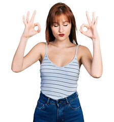 Canvas Print - Redhead young woman wearing casual style with sleeveless shirt relax and smiling with eyes closed doing meditation gesture with fingers. yoga concept.