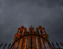 Front View From Below Of A Spear-finish Wrought Iron Fence Of The Church Of San Ildefonso Decorated With Portuguese Tiles Illuminated Beautifully Under A Gray And Cloudy Sky. Portugal.
