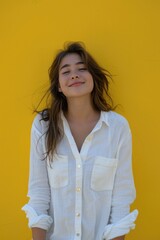 A woman standing in front of a yellow wall. Suitable for business or lifestyle concepts