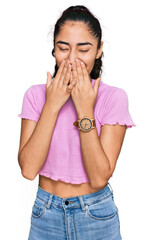 Wall Mural - Hispanic teenager girl with dental braces wearing casual clothes laughing and embarrassed giggle covering mouth with hands, gossip and scandal concept