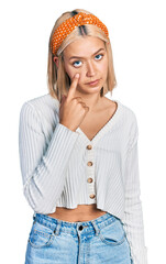 Poster - Beautiful young blonde woman wearing casual white sweater pointing to the eye watching you gesture, suspicious expression