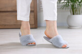 Fototapeta  - Woman in grey soft slippers at home, closeup