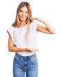 © Krakenimages.com - Beautiful caucasian woman with blonde hair wearing casual white tshirt gesturing with hands showing big and large size sign, measure symbol. smiling looking at the camera. measuring concept.