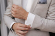 Close-up of a man fastening a cufflink on his shirt