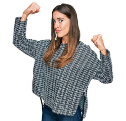 Canvas Print - Young beautiful woman wearing casual clothes showing arms muscles smiling proud. fitness concept.