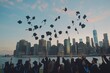 Graduation ceremony overlooking the city skyline as graduates throw their caps in the air. 