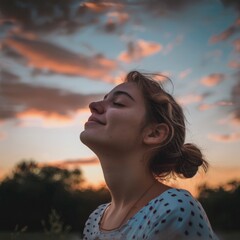 Canvas Print - A woman with her eyes closed looking up at the sky. Suitable for meditation or relaxation concepts