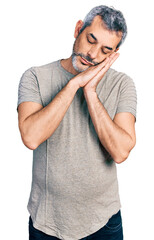 Poster - Middle age hispanic with grey hair wearing casual grey t shirt sleeping tired dreaming and posing with hands together while smiling with closed eyes.