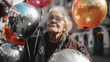 An elderly woman with glasses holds balloons on the street and rejoices