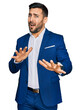 © Krakenimages.com - Young hispanic man wearing business jacket afraid and terrified with fear expression stop gesture with hands, shouting in shock. panic concept.