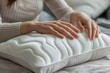 Closeup of woman touching memory foam pillow indoors