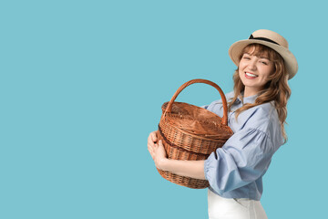 Sticker - Beautiful young woman with wicker basket on blue background