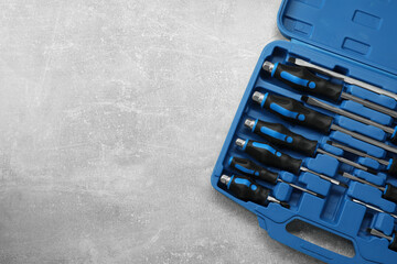 Poster - Set of screwdrivers in open toolbox on grey textured table, top view. Space for text
