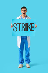 Wall Mural - Protesting male doctor holding placard with word STRIKE on blue background