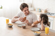 Caring young caucasian father dad eating croissants for breakfast together in the kitchen. Family time, parenthood and fatherhood. Happy father`s day! I love you, dad!