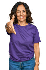 Sticker - Middle age hispanic woman wearing casual clothes smiling friendly offering handshake as greeting and welcoming. successful business.