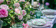 Table setting with rose flowers and candles for an event party or wedding reception in summer garden.