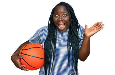 Sticker - Young black woman with braids holding basketball ball celebrating victory with happy smile and winner expression with raised hands