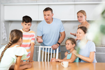 Wall Mural - Concept of big friendly family - children of different ages and parents communicate in the home kitchen